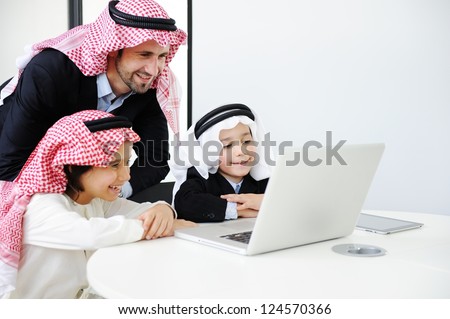 Middle eastern father with sons working on laptop