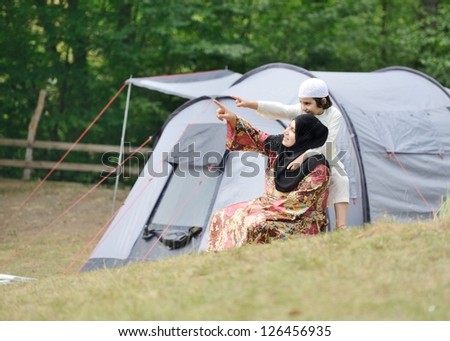 Muslim Arabic woman with her son camping in nature