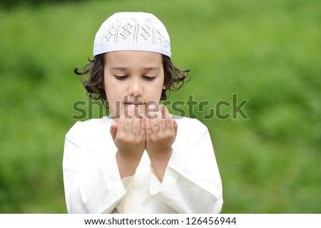 A little Arabic boy praying outdoor in nature
