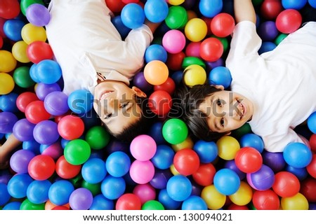 Happy children playing together and having fun at kindergarten with colorful balls