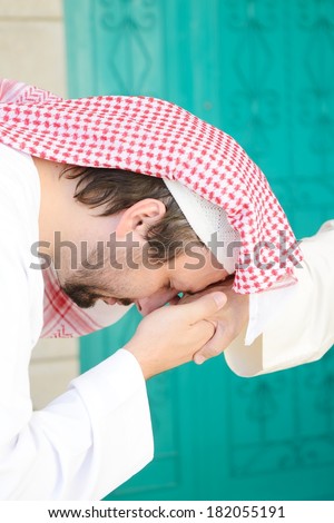 Arabic man kissing a hand from an old man