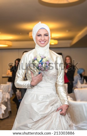 Muslim bride posing with bouquet at a celebration ceremony