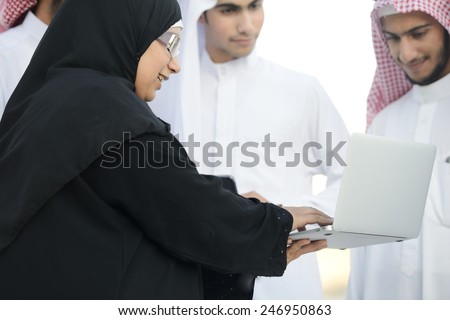 Young Arabic Muslim business woman leading group of Middle eastern Gulf guys