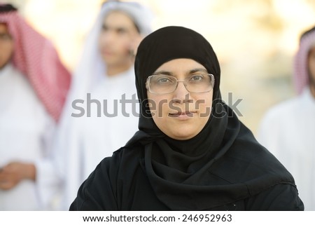 Arabic Muslim businesswoman leading group of Middle eastern Gulf people