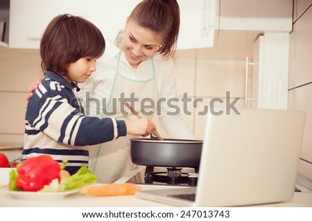 Mother and son preparing food in kitchen together
