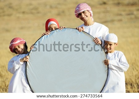 Arabic family in nature holding copy space banner
