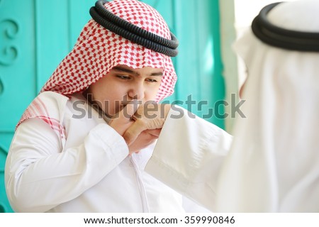 Arabic kid kissing parent for traditional act of respect