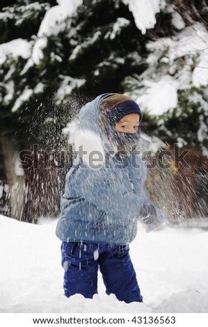 Child playing in the snow with snow on his face