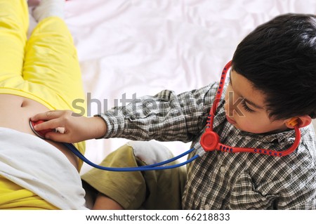 girl & boy playing with doctor\'s stethoscope toy