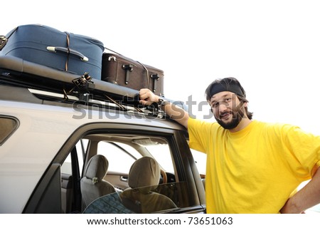 Young man preparing for trip, baggage on car roof