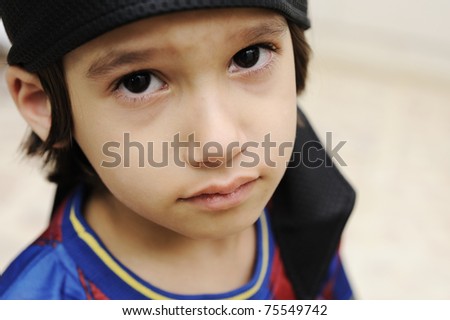 sad cry kid boy is looking at camera