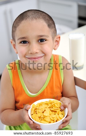 Happy kid with a glass of milk  and cornflakes