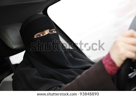 Arabic Muslim woman with veil and scarf (hijab and niqab) driving car