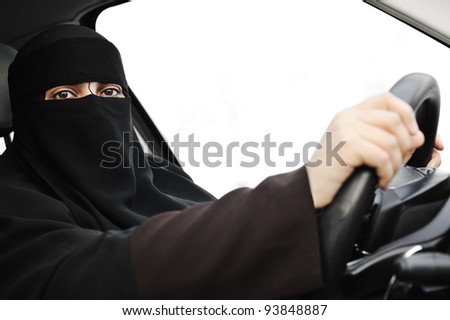 Arabic Muslim woman with veil and scarf (hijab and niqab) driving car