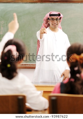 Arabic Muslim teacher in classroom with children. Competition and success.