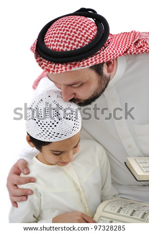 Middle eastern education father kissing son while reading Koran Middle eastern education father kissing son while reading Koran