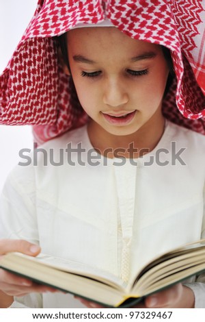 Muslim Arabic little boy reading Qoran