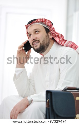 Middle Eastern Businessman with suitcase and cell phone