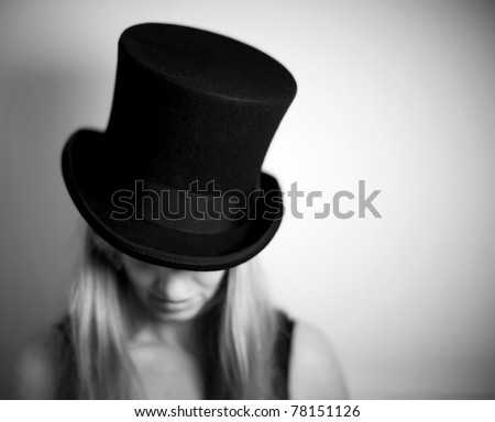 Woman in top hat looking down