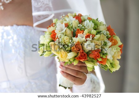 Multi-coloured bouquet in the hands of bride.