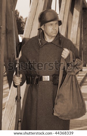 Old style picture with man in soldier uniform with weapon. Costume is authentic to the ones weared in time of  World War I.