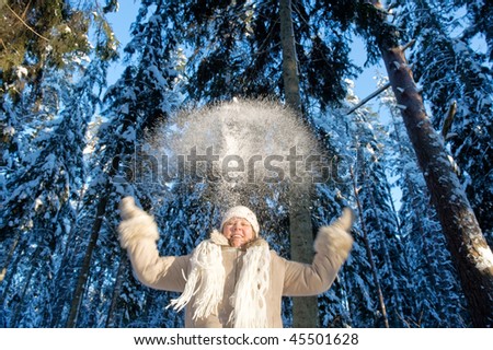 Happy middle-aged women having fun on winters day in forest.