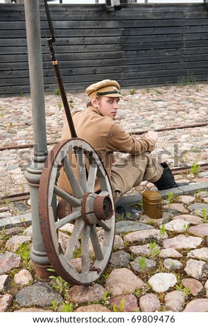 Soldier in uniform of World War I, sit down, resting on the pavement and smoking. Costume accord the times of World War I. Photo made at cinema city Cinevilla in Latvia.
