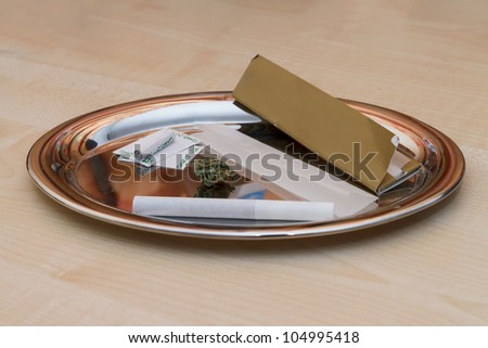 All what you need to roll a joint on a silver platter on wooden table