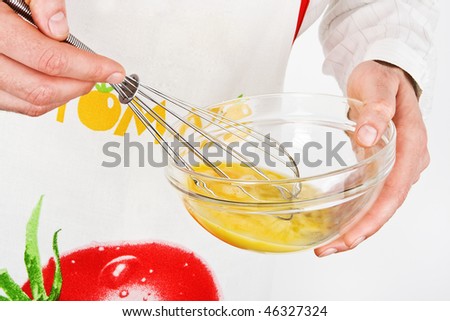 Male chef beating eggs for baking.