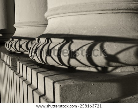 Columns of St. Louis Cathedral in New Orleans with shadow cast by wrought iron fence.