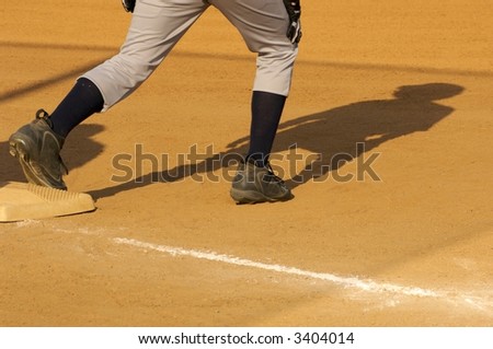 Young baseball player preparing to run with foot on the base