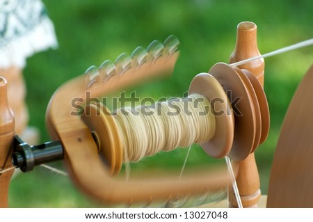 Wool being spun on bobbin making wool yarn on traditional spinning wheel