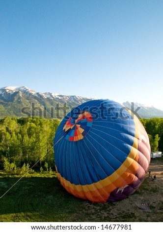 Ground crew preparing for launch of hot air balloon by filling balloon with hot air