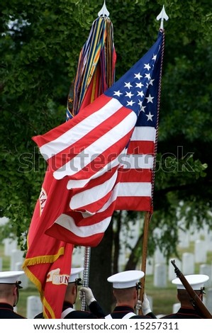 US flag and honor guard with gravestones in background Arlington National Cemetery
