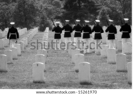 Black and white horizontal photo of military honor guard preparing to fire final salute at funeral at Arlington National Cemetery