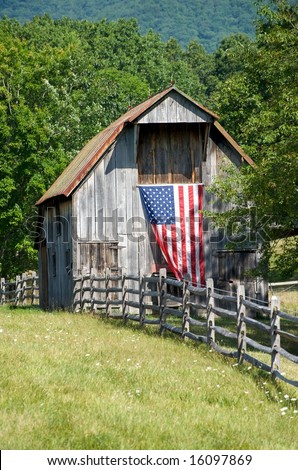 Vertical photo of old wooden barn with fluttering US flag