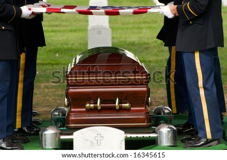Flag being lifted from casket during burial at Arlington National Cemetery