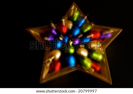 Horizontal photo of gold star holding Christmas balls with zoom effect during exposure