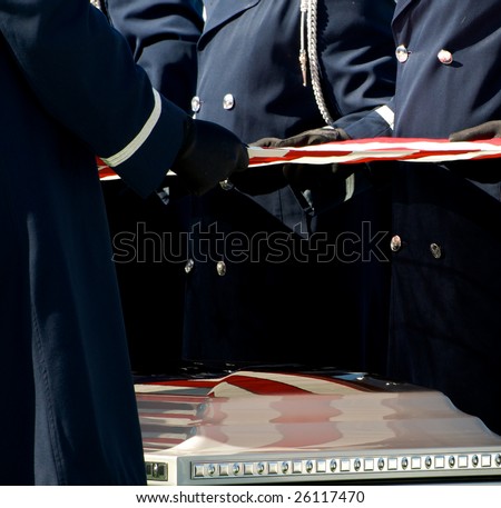 Casket at military funeral at Arlington National Cemetery with American flag reflected on casket
