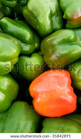 Close-up photo of group of green bell peppers with one red pepper