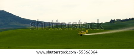 Crop dusting airplane spraying pesticide on wheat fields in the Palousezfz