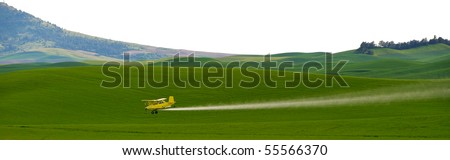 Crop dusting airplane spraying pesticide on wheat fields in the Palousezf