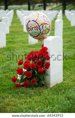 Tombstones at Arlington National Cemetery with flowers and balloon