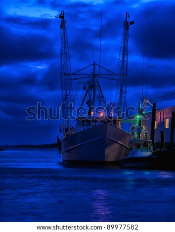 Fishing boat tied up at pier in Nags Head, North Carolina as dawn begins to break