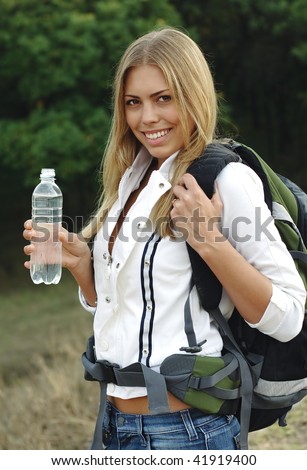 Beautiful girl with a backpack, drink mineral water.