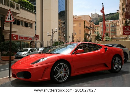 MONACO, MONTE CARLO - JUNE 12, 2008: Luxury car Ferrari parked near store selling car. Expensive cars and other material symbols are visible everywhere.