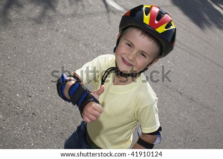 The happy boy on the roller blades and in a crash helmet.