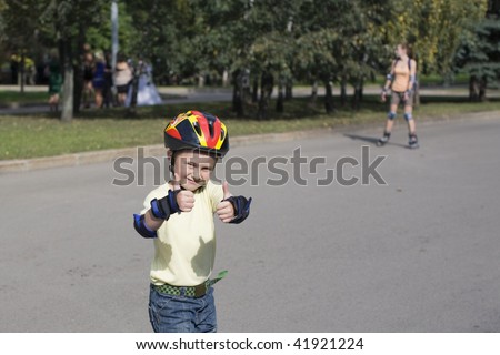 The happy boy on the roller blades and in a crash helmet.