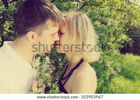 Young couple kissing near the blooming hawthorn