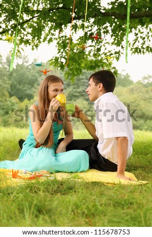 Couple drinking tea under a tree with paper cranes